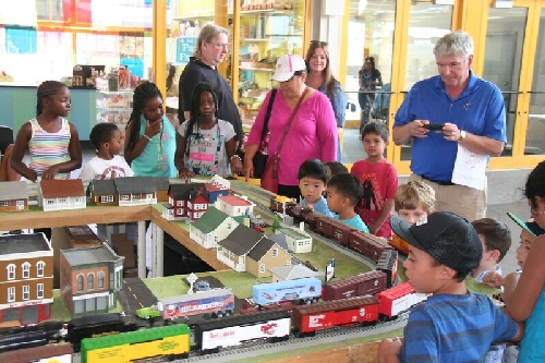 Children gather as the model train layout comes to life at the Long Island Childrens Museum with Lionel Club Ambassador Nassau Lionel Operating Engineers Lionel Club Ambassador Nassau Lionel Operating Engineers at the Long Island Childrens Museum display their model train layout and children gather to watch