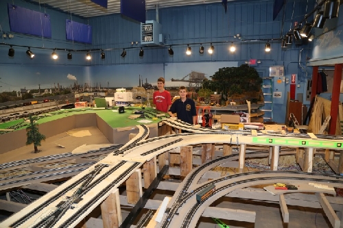 Scouts look over the intricate track plan at the CLRC Club Ambassadors to Lionel Open House July 9 2016 Chicagoland Lionel Railroad Club Lionel Club Ambassador Open House July 9 2016 show Scouts the intricate track plan on the new layout