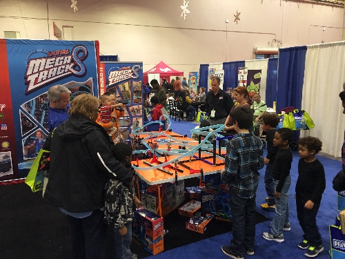 Families are engaging with the Lionel Mega Tracks display at the Chicago Toy  Game Week at Navy Pier Festival Hall